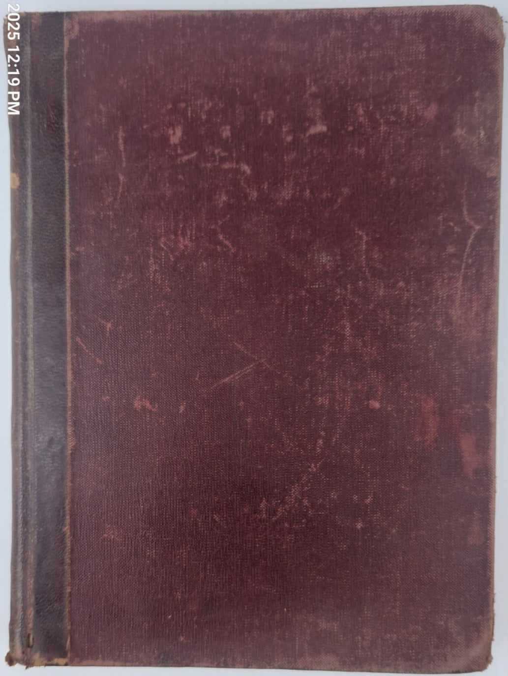 Brown bound book on a white surface with a blurred background